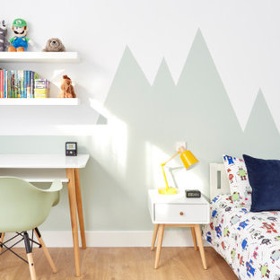 Diseño de habitación infantil unisex de 4 a 10 años, actual, de tamaño medio, con escritorio, paredes verdes, suelo de madera clara y suelo beige