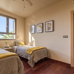 Foto di una cameretta per bambini mediterranea di medie dimensioni con pareti beige, pavimento in laminato e pavimento marrone