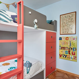 Foto de dormitorio infantil ecléctico con paredes azules, suelo de madera en tonos medios y suelo marrón