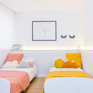 Diseño de dormitorio infantil de 1 a 3 años, nórdico, de tamaño medio, con paredes blancas, suelo de madera en tonos medios y suelo marrón