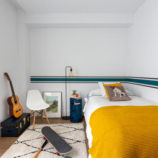 Modelo de dormitorio infantil contemporáneo, de tamaño medio, con paredes blancas y suelo marrón