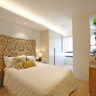 Diseño de dormitorio infantil contemporáneo con paredes blancas, suelo de madera clara y suelo beige