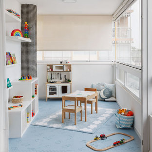 Modelo de dormitorio infantil de 1 a 3 años, actual, de tamaño medio, con paredes blancas y suelo azul