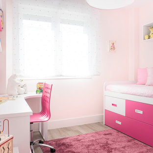 Ejemplo de habitación de niña de 4 a 10 años, actual, con paredes rosas, suelo de madera clara y suelo beige