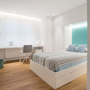 Modelo de dormitorio infantil actual, grande, con paredes blancas, suelo de madera en tonos medios y suelo beige
