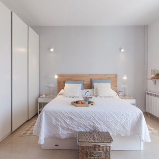 Ejemplo de dormitorio contemporáneo, de tamaño medio, con paredes blancas, suelo de baldosas de porcelana y suelo beige