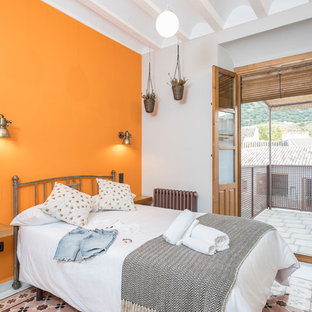 Modelo de dormitorio mediterráneo con parades naranjas y suelo multicolor