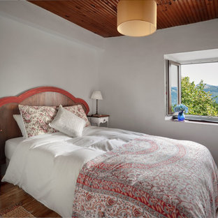 Imagen de habitación de invitados rural, de tamaño medio, con paredes blancas, suelo de madera oscura y suelo marrón