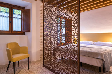 Foto de dormitorio minimalista de tamaño medio con paredes blancas, suelo de baldosas de cerámica y suelo multicolor