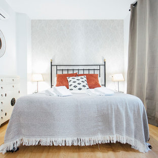 Foto de dormitorio tradicional renovado, de tamaño medio, sin chimenea, con paredes blancas, suelo de madera en tonos medios y suelo marrón
