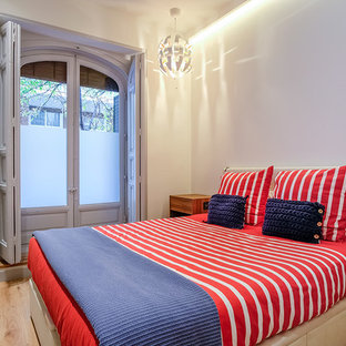 Ejemplo de dormitorio actual, de tamaño medio, sin chimenea, con paredes blancas y suelo de madera en tonos medios
