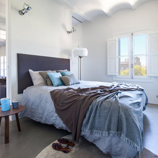 Imagen de dormitorio principal, actual, de tamaño medio, sin chimenea, con paredes blancas, suelo de cemento y suelo gris