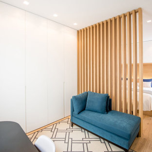 Modelo de dormitorio tipo loft, minimalista, de tamaño medio, con paredes blancas y suelo de baldosas de cerámica