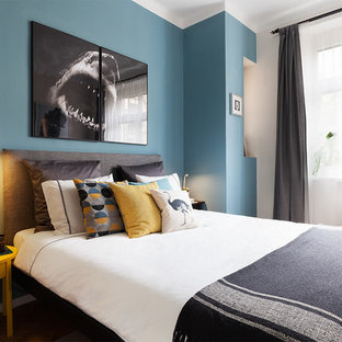 Modelo de dormitorio principal, nórdico, pequeño, con paredes azules, suelo de madera en tonos medios y suelo marrón