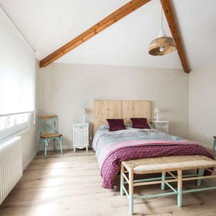 Modelo de dormitorio principal, mediterráneo, con paredes beige, suelo de madera clara y suelo marrón