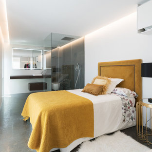 Imagen de dormitorio actual con paredes blancas, suelo de cemento y suelo gris