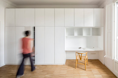 Exemple d'une chambre parentale scandinave de taille moyenne avec un mur blanc, un sol en bois brun et un sol multicolore.