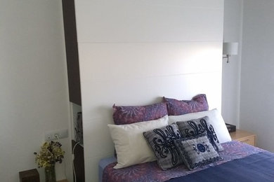 Ejemplo de dormitorio principal contemporáneo pequeño con paredes blancas y suelo de madera clara