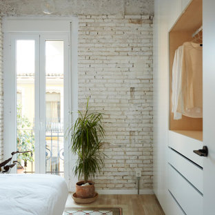 Modernes Schlafzimmer mit weißer Wandfarbe, hellem Holzboden, beigem Boden und Ziegelwänden in Valencia