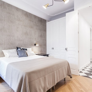 Modelo de dormitorio principal, contemporáneo, de tamaño medio, sin chimenea, con paredes grises, suelo de madera en tonos medios y suelo marrón