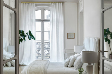 Diseño de dormitorio principal clásico renovado grande sin chimenea con paredes blancas y suelo de madera oscura