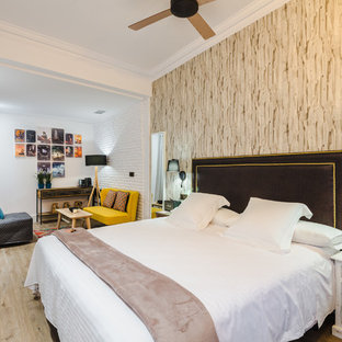 Large bohemian master bedroom in Bilbao with white walls, light hardwood flooring and no fireplace.
