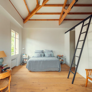 Imagen de dormitorio principal, mediterráneo, con paredes blancas, suelo de madera en tonos medios y suelo beige