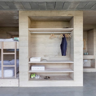 Imagen de habitación de invitados moderna con paredes beige, suelo de cemento y suelo gris