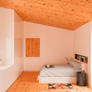 Modelo de dormitorio principal, mediterráneo, de tamaño medio, con paredes blancas, suelo de madera clara y suelo naranja