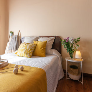 Diseño de dormitorio mediterráneo, de tamaño medio, con paredes beige, suelo de madera en tonos medios y suelo marrón