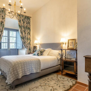 Aménagement d'une chambre méditerranéenne avec un mur blanc et un sol marron.