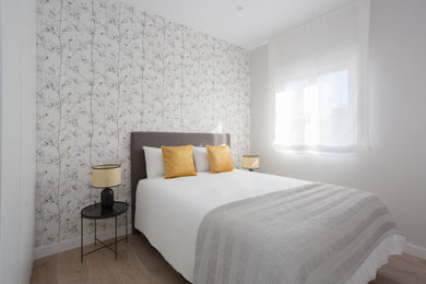Ejemplo de dormitorio principal minimalista pequeño con paredes grises y suelo laminado