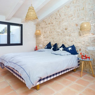 Ejemplo de dormitorio mediterráneo con paredes beige, suelo de baldosas de terracota y suelo naranja