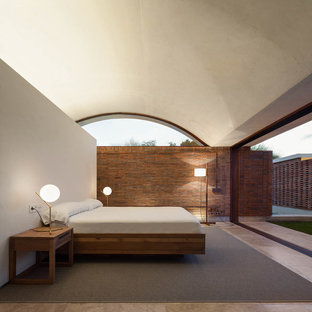 Imagen de dormitorio principal, minimalista, de tamaño medio, sin chimenea, con suelo de travertino y paredes beige