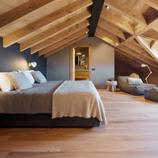 Imagen de habitación de invitados campestre, grande, con suelo de madera clara, paredes grises y suelo beige