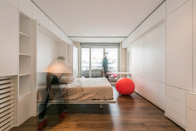 Cette image montre une grande chambre parentale design avec un mur blanc, un sol en bois brun et aucune cheminée.