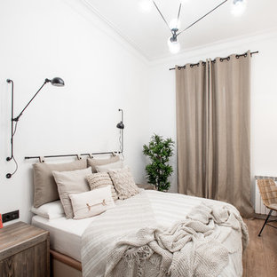 Foto de habitación de invitados campestre con paredes blancas, suelo de madera en tonos medios y suelo marrón