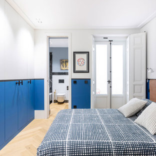 Foto de dormitorio contemporáneo con paredes blancas, suelo de madera clara y suelo beige