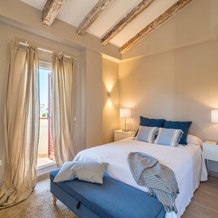 Diseño de dormitorio principal, mediterráneo, con paredes beige, suelo de madera en tonos medios y suelo marrón