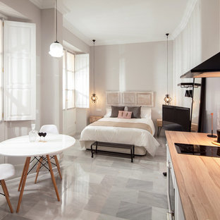 Imagen de dormitorio tipo loft, minimalista, de tamaño medio, sin chimenea, con paredes grises, suelo de mármol y suelo blanco