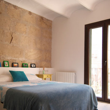 Dormitorio con cabecero de piedra