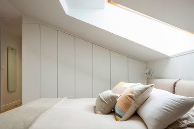 Modelo de dormitorio principal actual con paredes blancas y suelo de madera clara