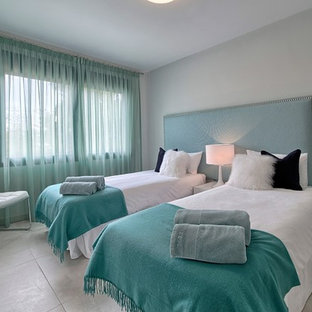 Imagen de habitación de invitados nórdica, de tamaño medio, con paredes grises, suelo de baldosas de porcelana y suelo gris