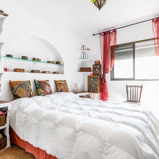 Imagen de habitación de invitados exótica con paredes blancas y suelo marrón