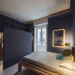Modelo de dormitorio principal, contemporáneo, de tamaño medio, con paredes azules, suelo de cemento y suelo azul