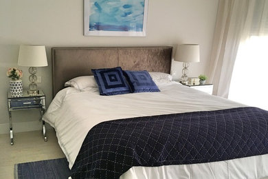 Imagen de dormitorio principal minimalista de tamaño medio sin chimenea con paredes grises, suelo de madera clara y suelo gris