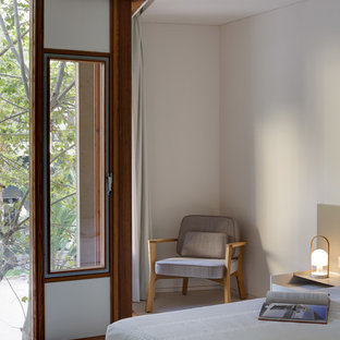 Imagen de dormitorio principal, moderno, con paredes blancas, suelo de cemento y suelo blanco
