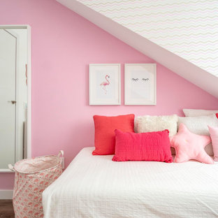 Modelo de dormitorio actual con paredes rosas, suelo de madera oscura y suelo marrón