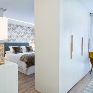 Foto de dormitorio principal, actual, con paredes blancas, suelo de madera en tonos medios y suelo marrón