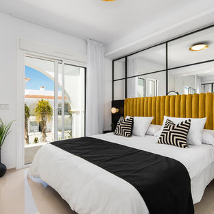 Diseño de dormitorio contemporáneo con paredes blancas y suelo beige